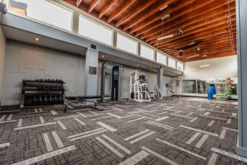 the lobby of a gym with a tile floor and wood ceilings